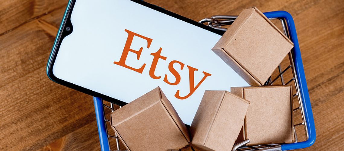 Kazan, Russia - Oct 6, 2021: Etsy is American e-commerce company focused on handmade items and craft supplies. Smartphone with Etsy logo on the screen and parcels in shopping cart.